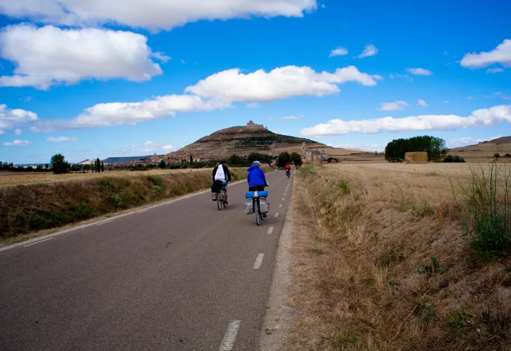Dos personas montando en bici por la carretera