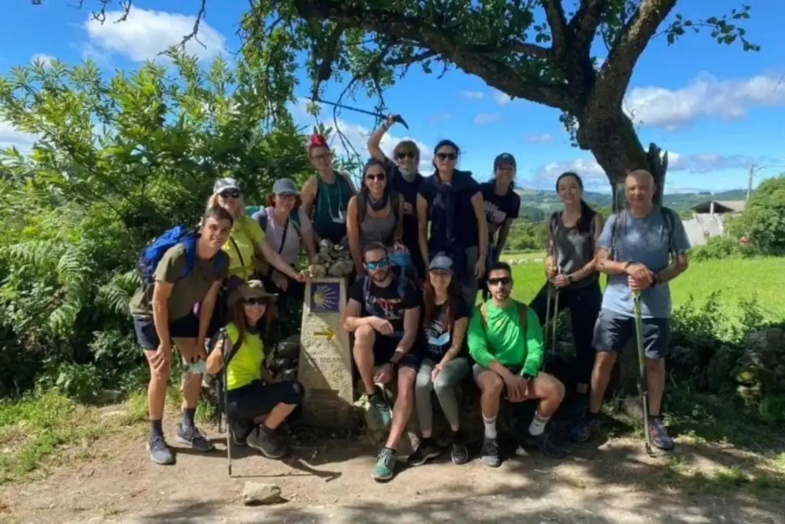 Peregrinos junto al mojón de 100km