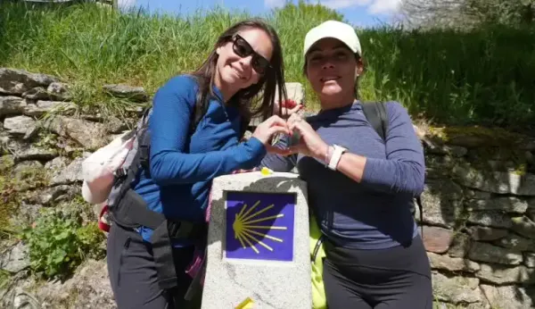 Peregrinas en un mojón posando a cámara 