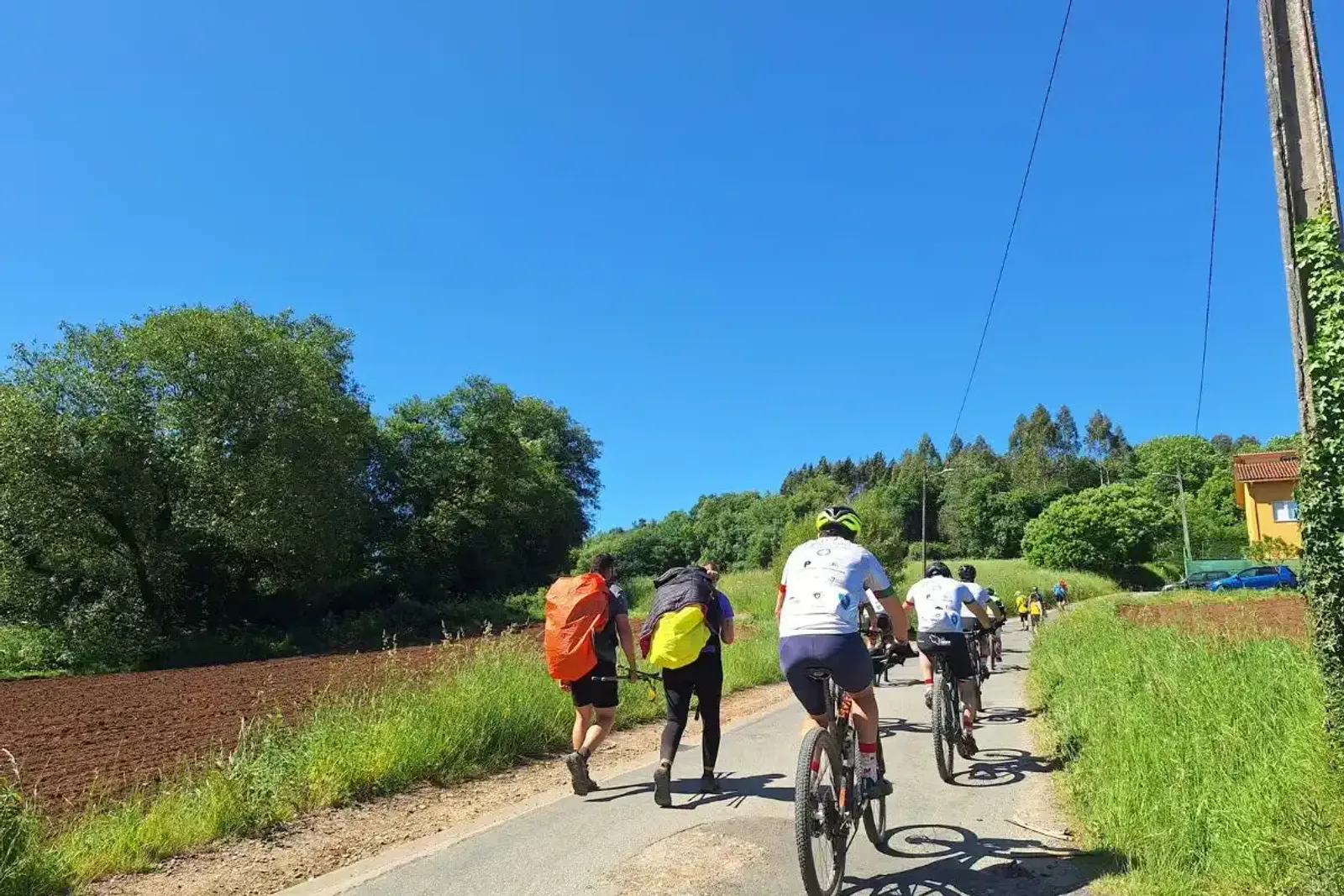 Peregrinos en Bici libres de equipaje pasando junto a peregrinos a pie